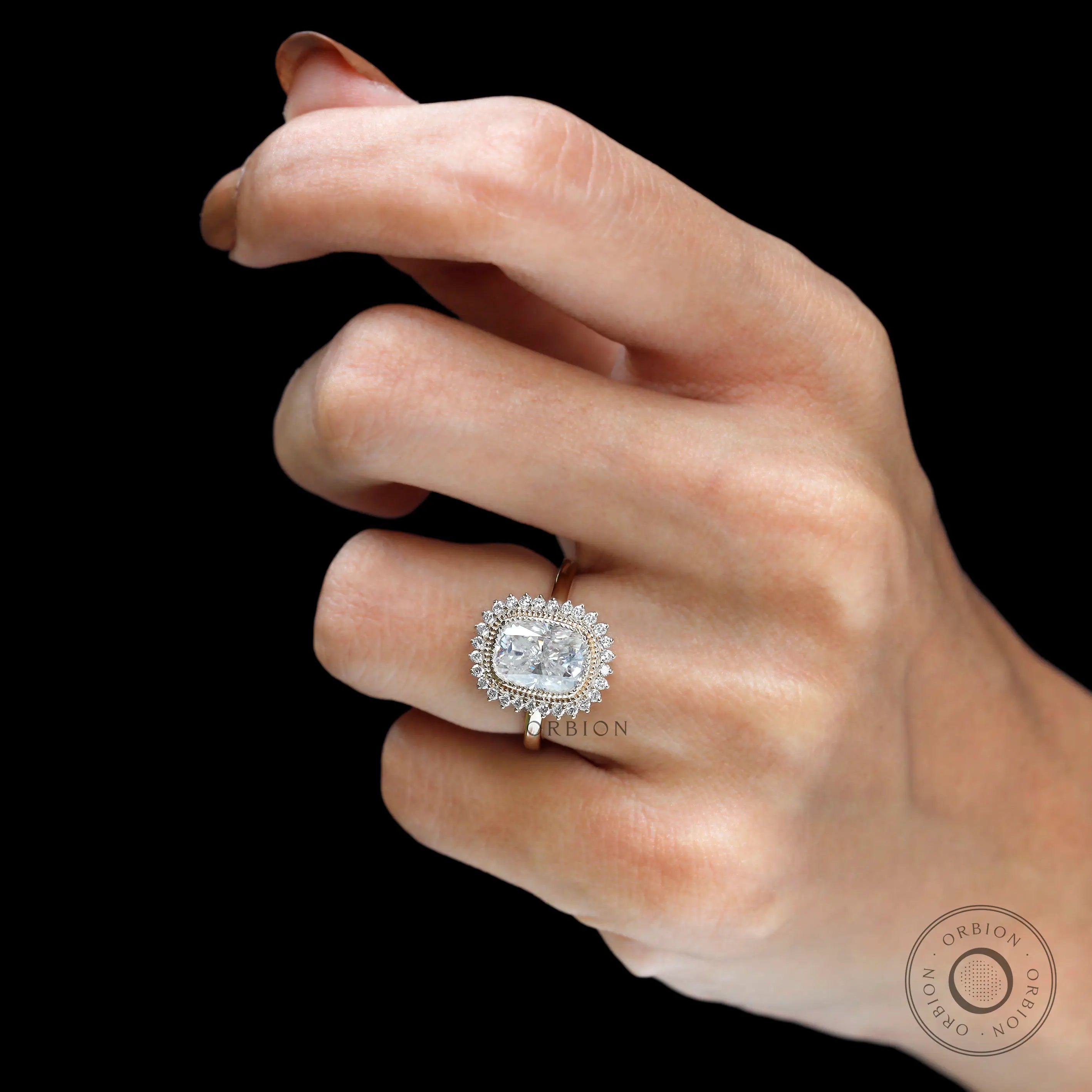 Yellow gold halo ring with round accent stones on fingure
