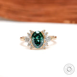Front view of green oval moissanite floral cluster ring in yellow gold
