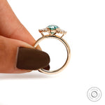 Angled side view highlighting oval green moissanite and prong details