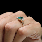 Top view emphasizing green oval center stone with diamond halo cluster