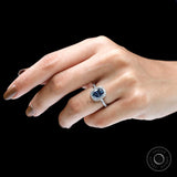 Dark blue moissanite halo engagement ring on fingure