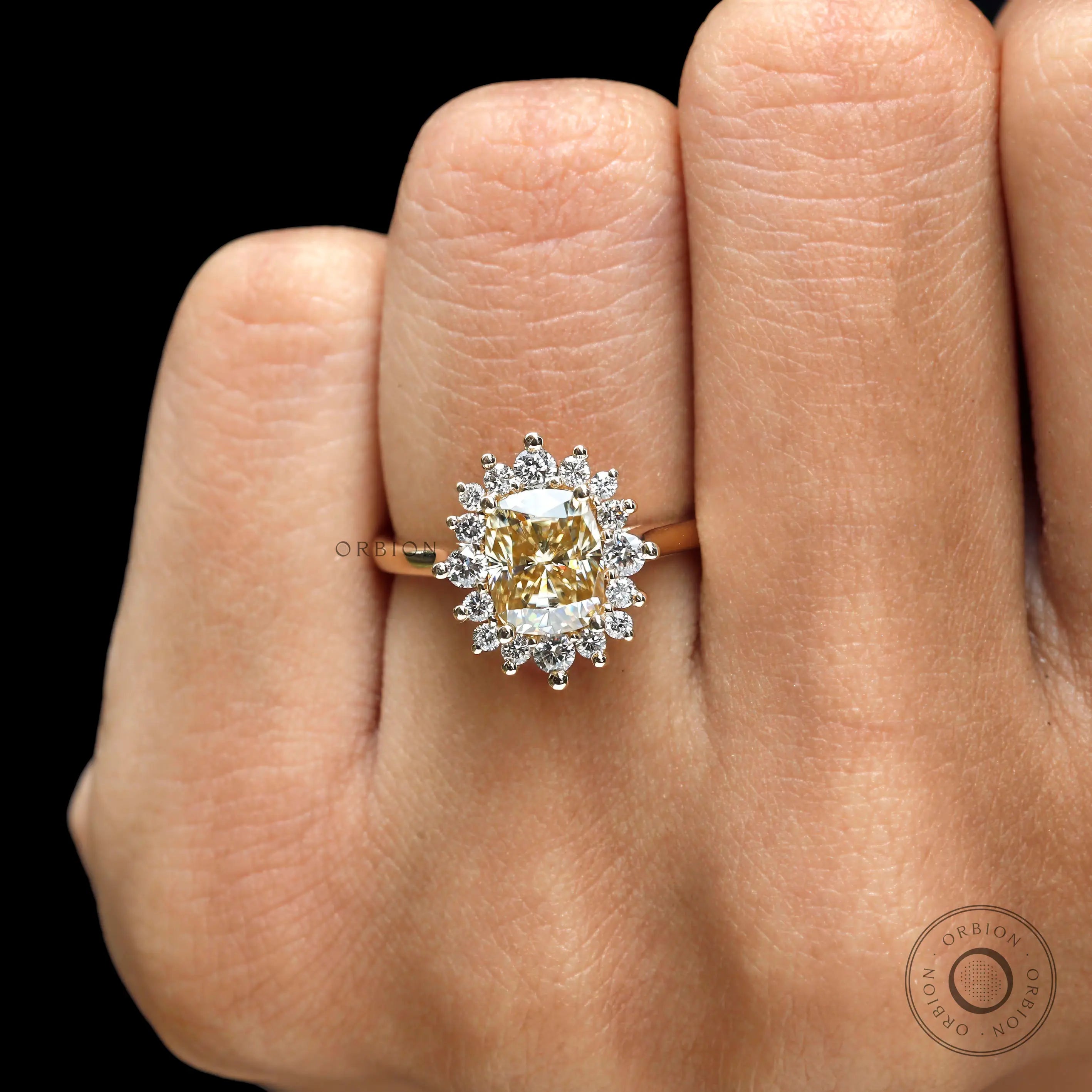Yellow gold halo engagement ring with elongated cushion champagne moissanite on fingure