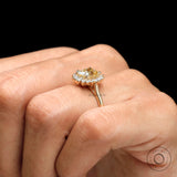 Yellow gold halo engagement ring with elongated cushion moissanite on hand