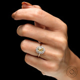 Yellow gold halo ring showing prong setting on fingure