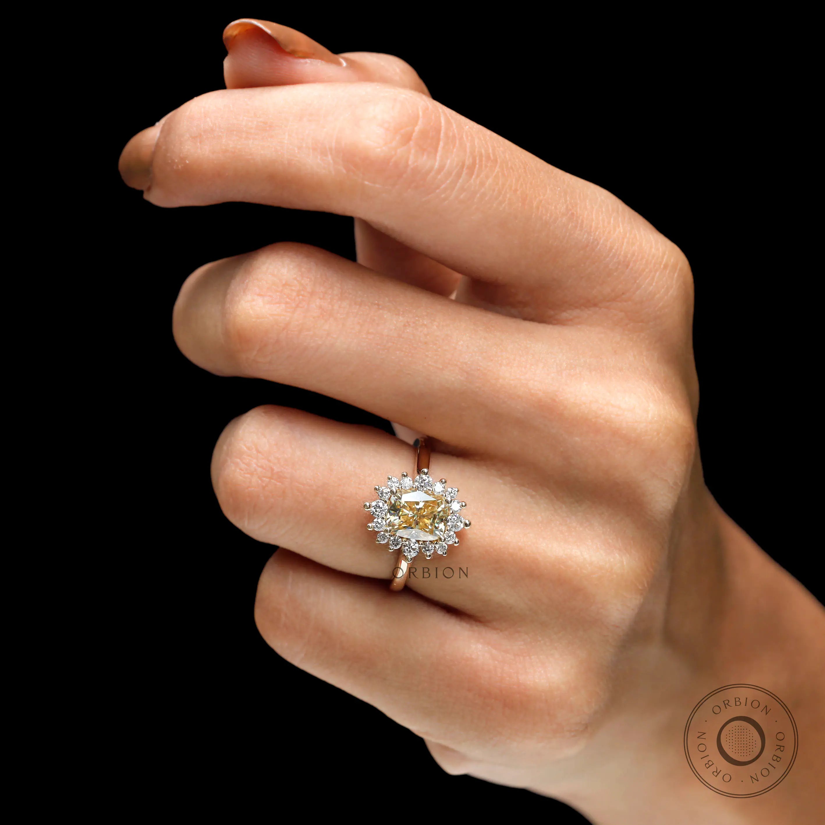Yellow gold halo ring showing prong setting on fingure