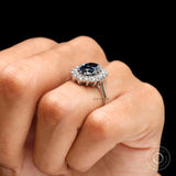 Oval deep blue moissanite halo engagement ring on hand