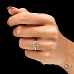 Halo engagement ring with pear shaped center stone on fingure