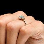 Blue green moissanite engagement ring on hand angle view