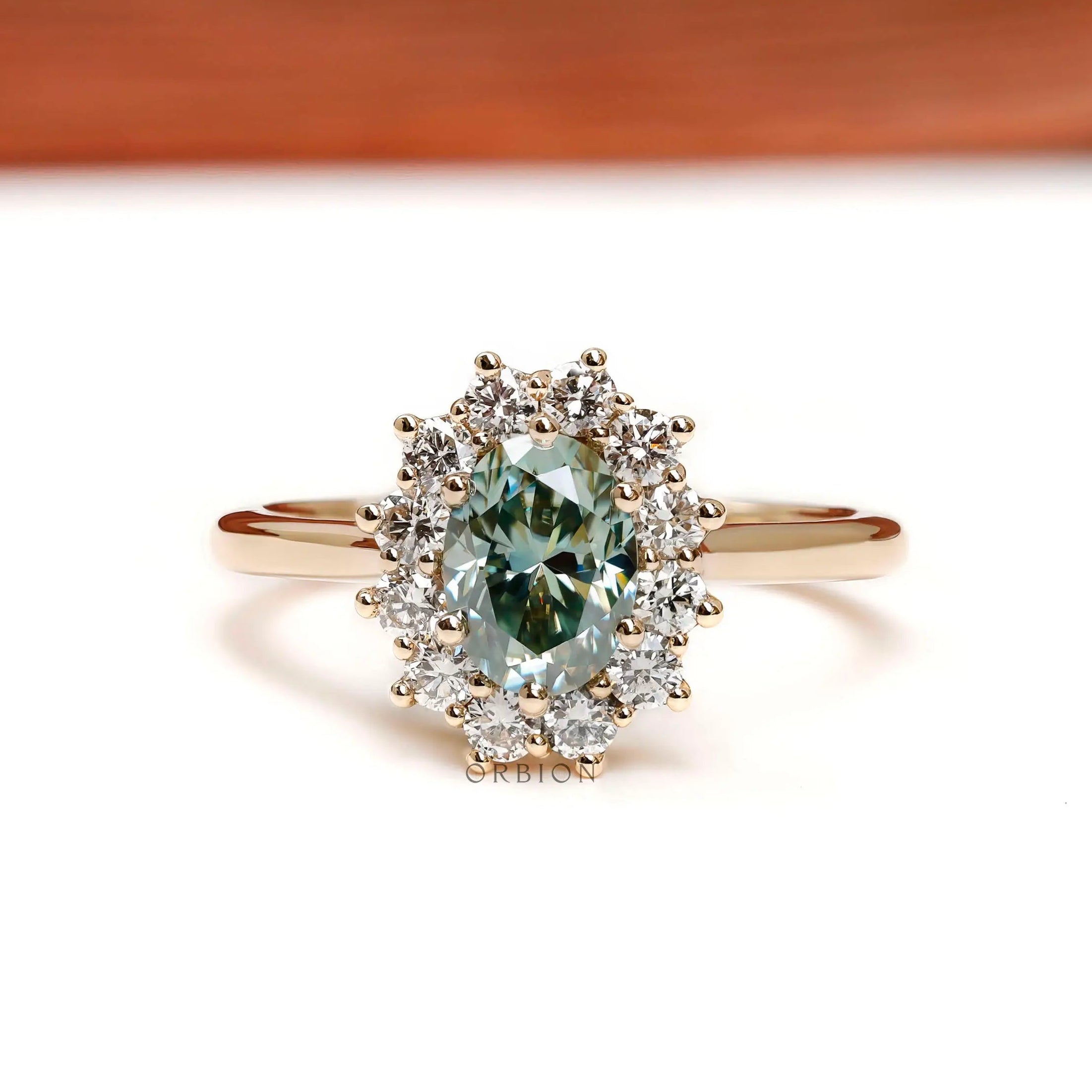 Oval blue green moissanite halo engagement ring in yellow gold