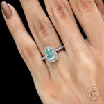 Pear shaped light green moissanite ring with diamond halo on fingure