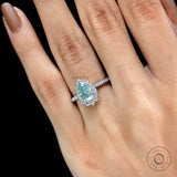Pear shaped light green moissanite ring with diamond halo on fingure