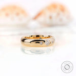 Angled view of solid gold gypsy set wedding band with Asscher cut moissanite