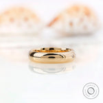 Side profile of flush set moissanite wedding band showing smooth polished gold
