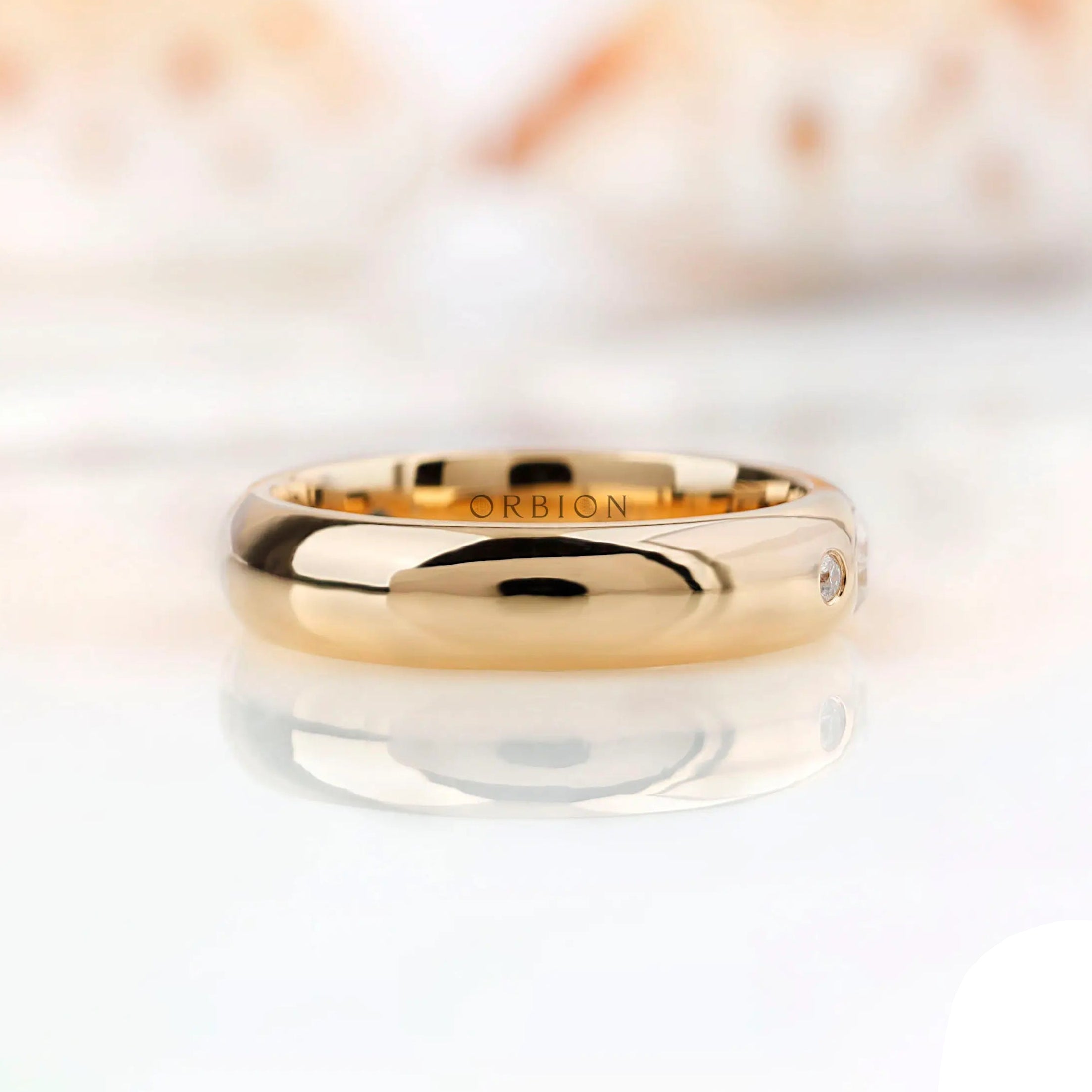 Side profile of flush set moissanite wedding band showing smooth polished gold