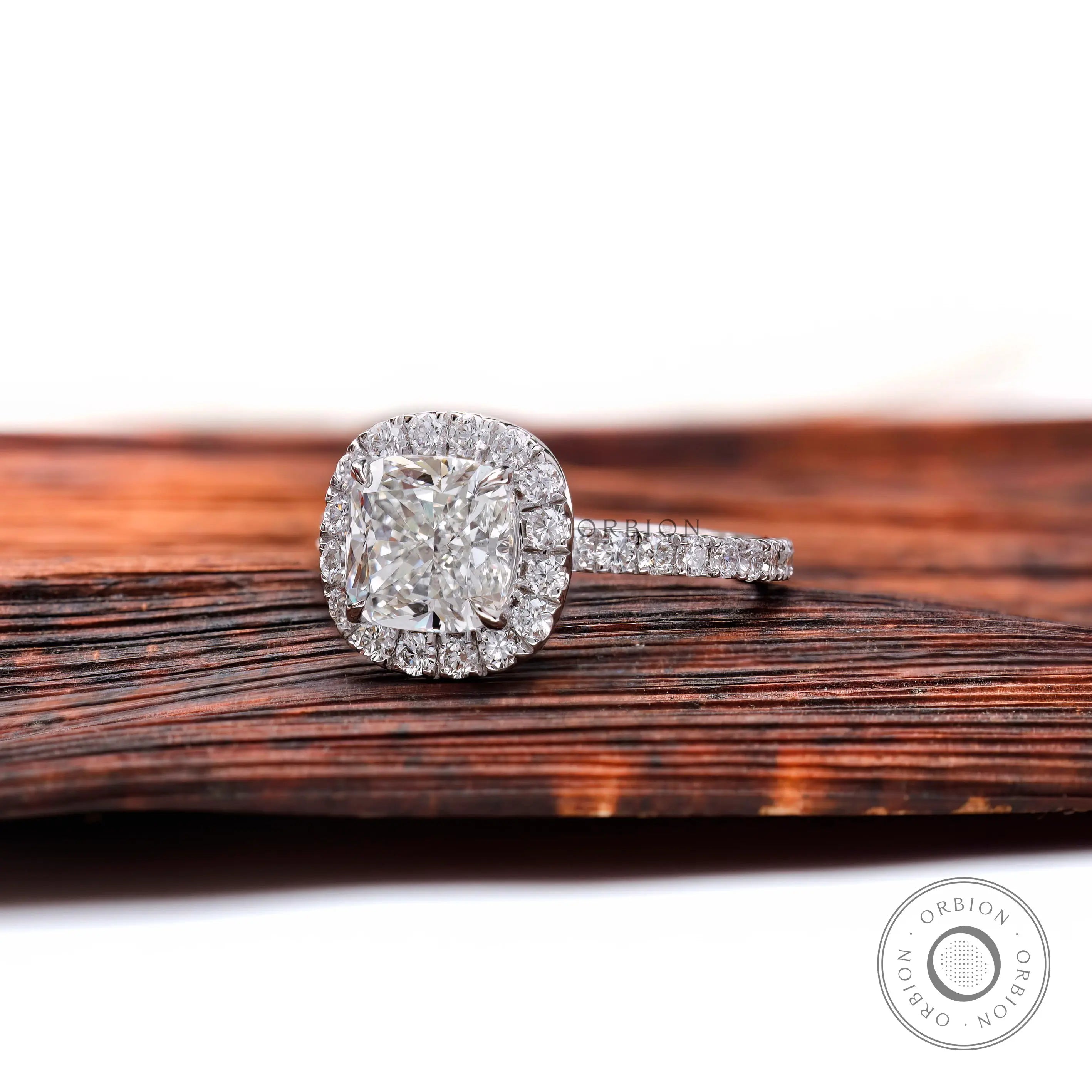 Cushion cluster halo engagement ring with pavé band, angled view