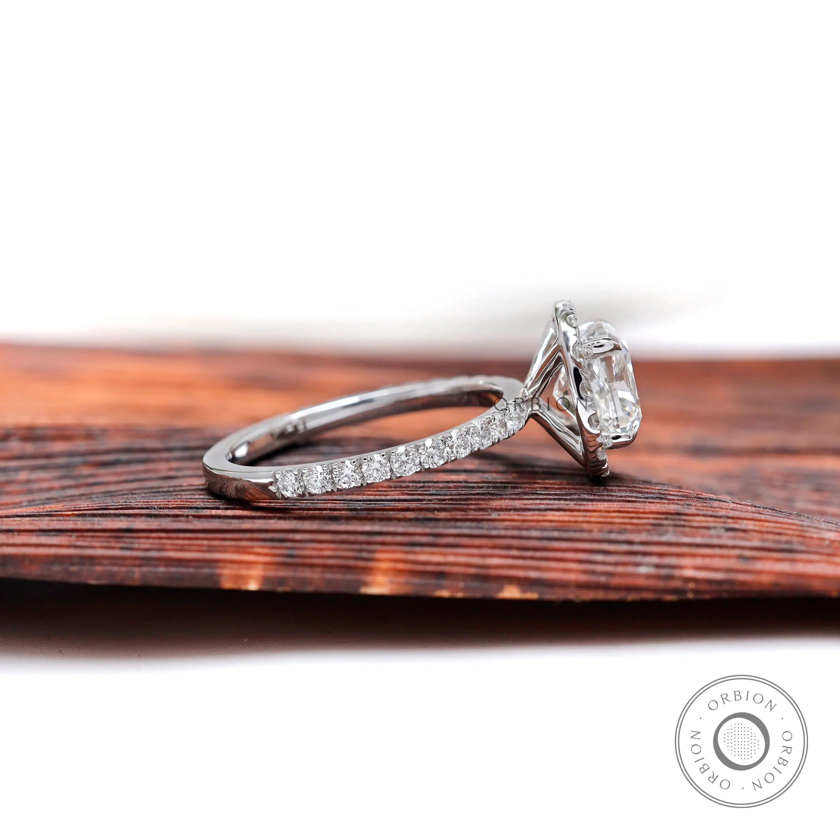 Side profile of cushion cluster halo ring showing elevated basket