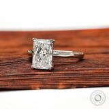 Radiant diamond solitaire ring displayed on wooden surface