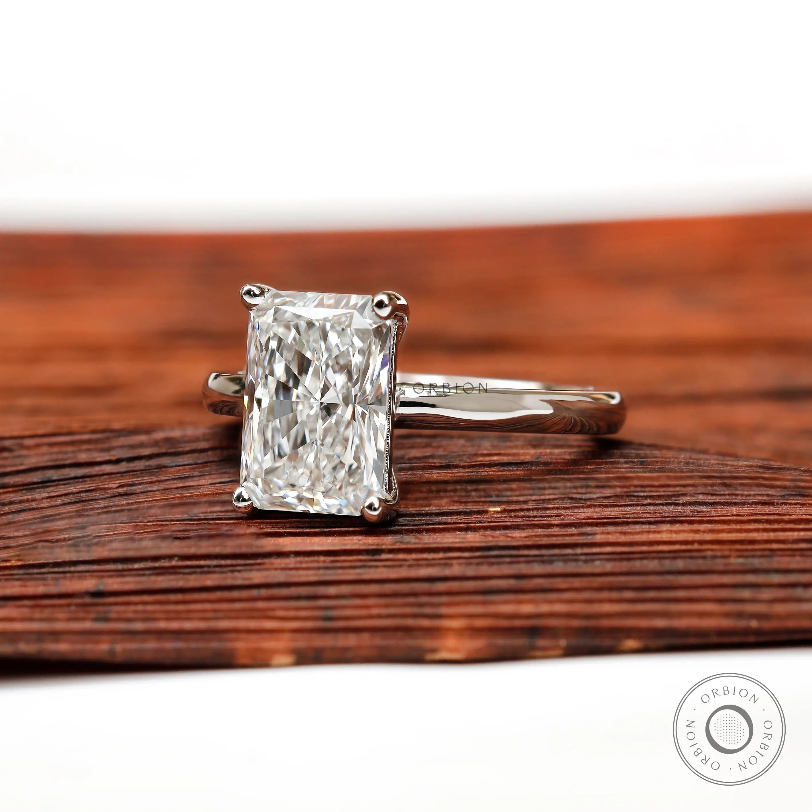 Radiant diamond solitaire ring displayed on wooden surface