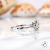 Side view of Asscher cut Moissanite ring with prong setting on a white marble surface.