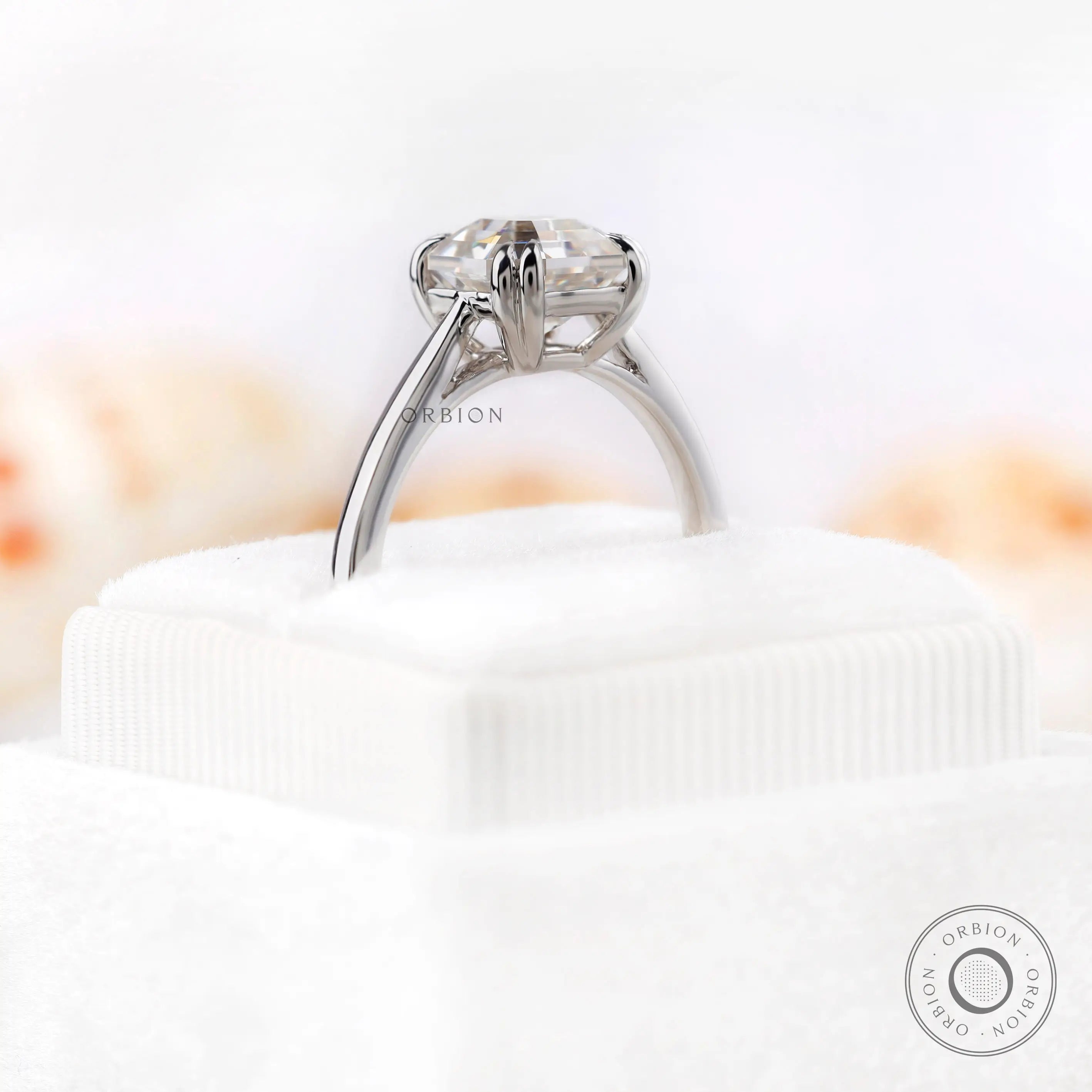 Side profile of Asscher cut Moissanite solitaire ring on a white velvet display.