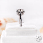 Close-up view of Asscher cut Moissanite solitaire ring on a white velvet display with reflection.