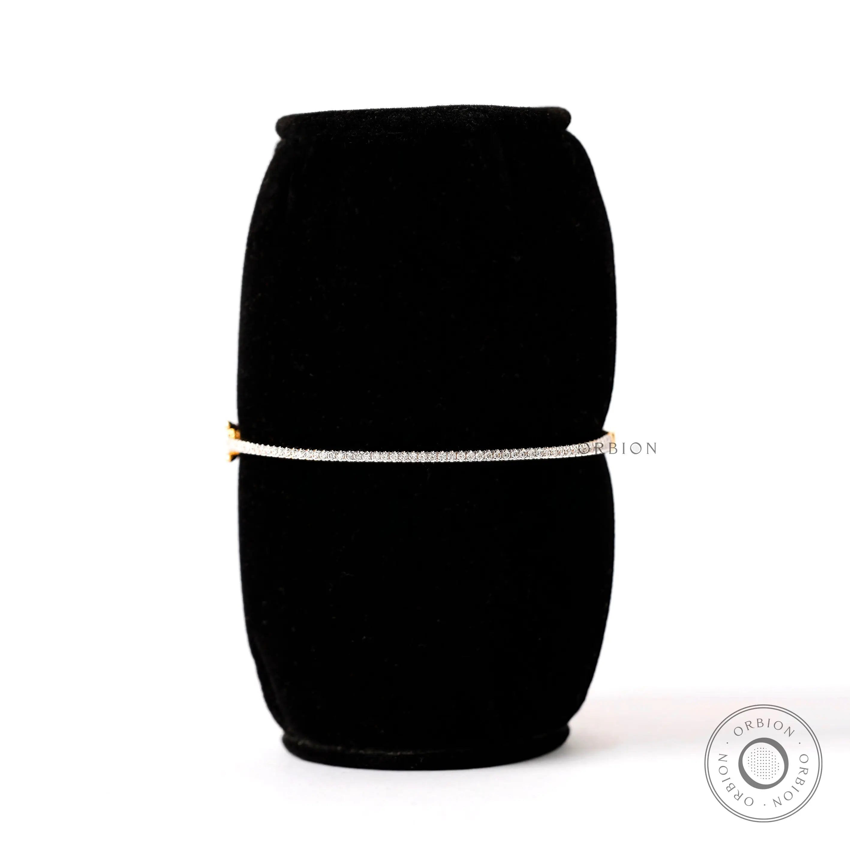 Dainty lab grown diamond bangle bracelet displayed on black stand