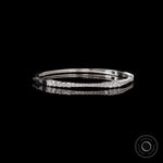 Angled side view of solid gold diamond bangle bracelet showing seamless lock