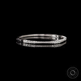 Angled side view of solid gold diamond bangle bracelet showing seamless lock