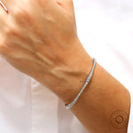 Close up of graduating lab grown diamonds set in solid gold bangle
