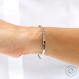 Graduating diamond bangle bracelet worn on wrist for size reference