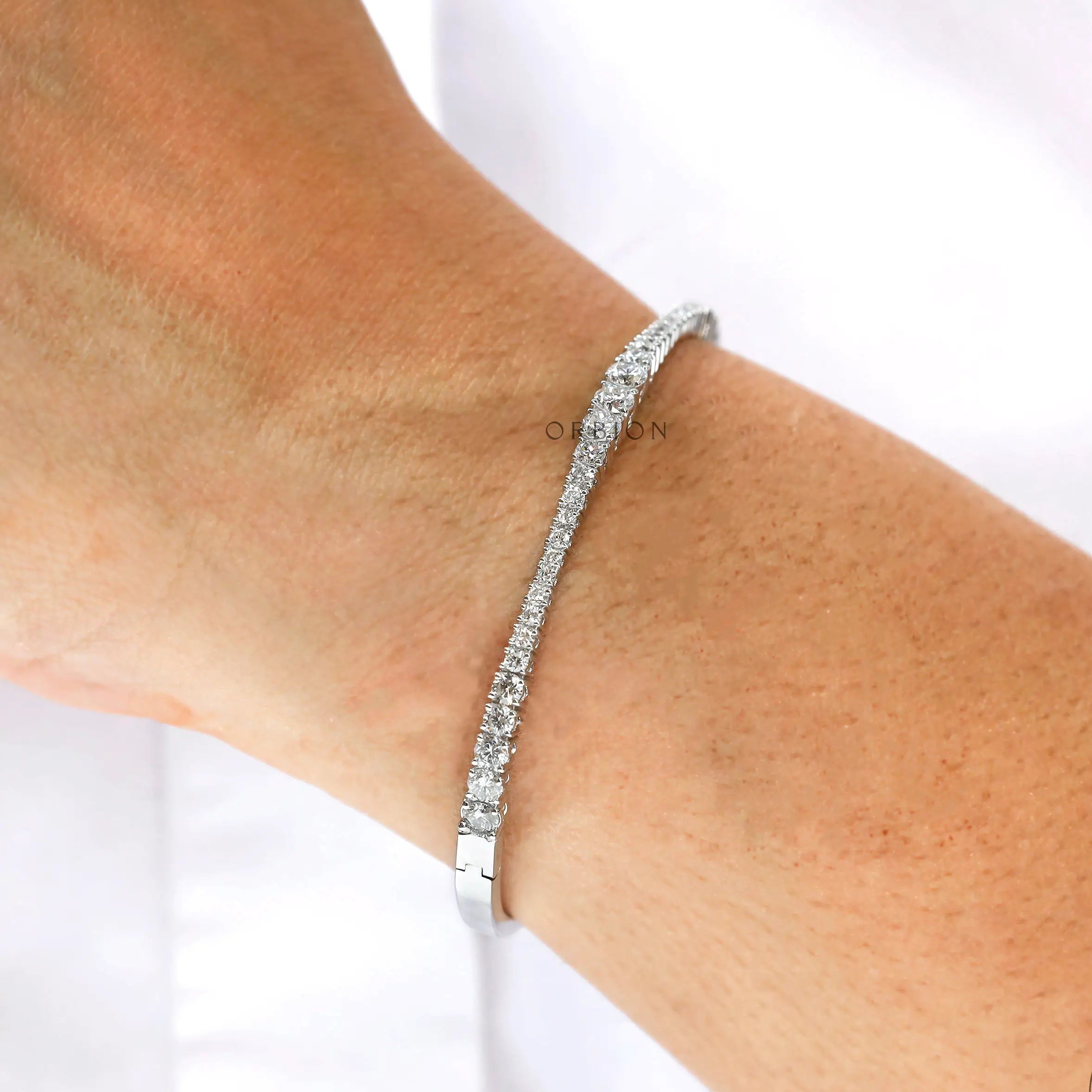 Everyday wear solid gold graduating diamond bangle bracelet on wrist