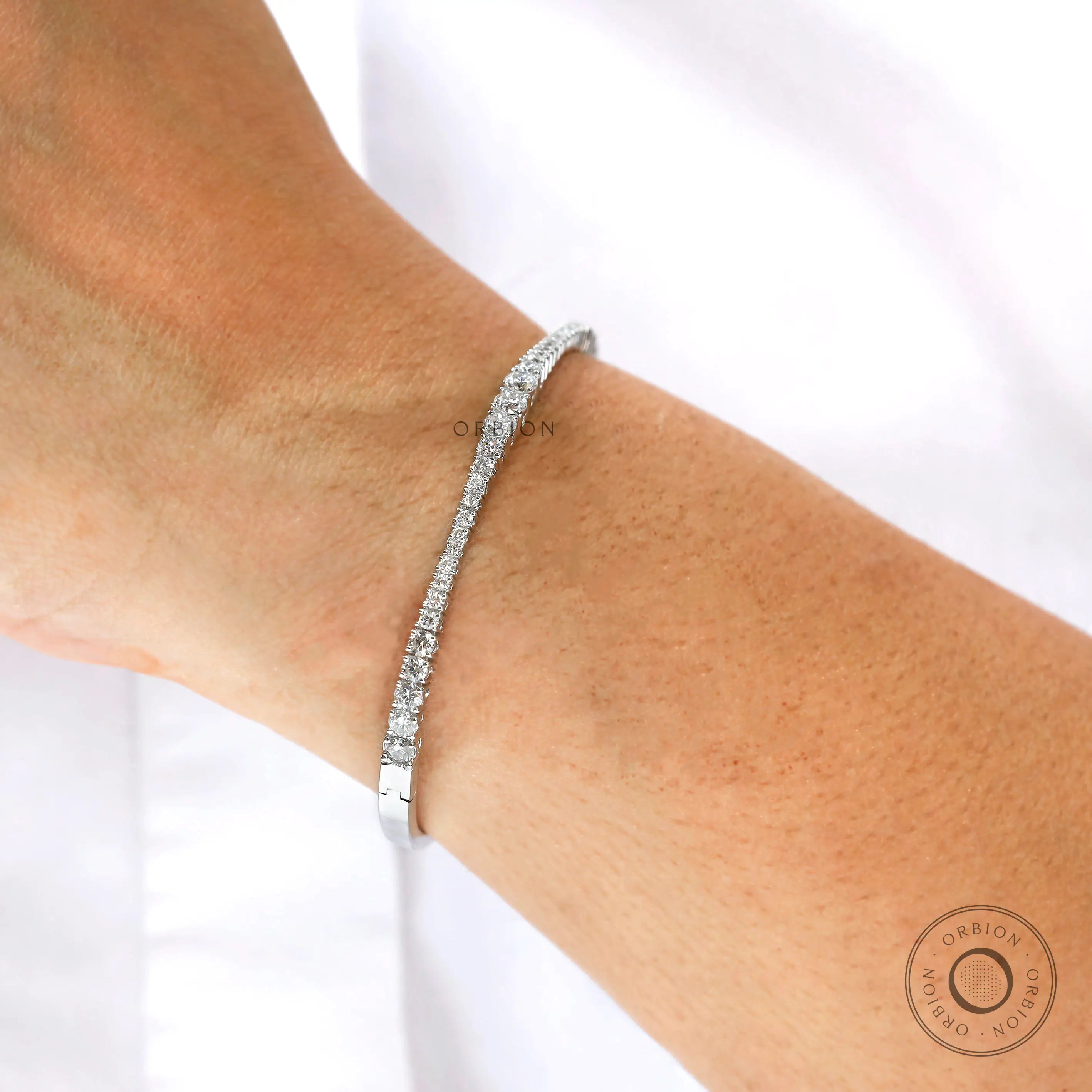 Everyday wear solid gold graduating diamond bangle bracelet on wrist