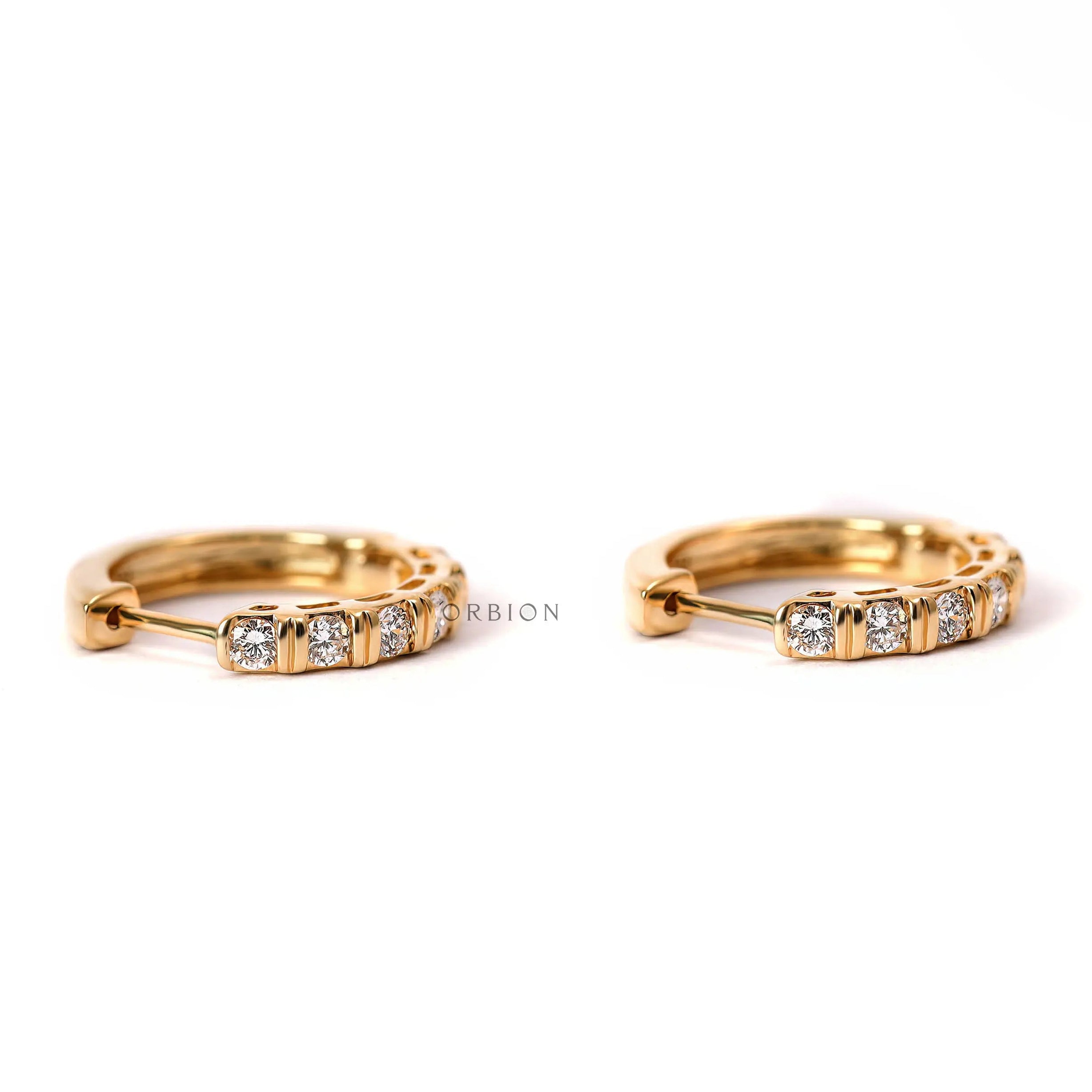 Yellow gold huggie hoop earrings with 2mm round lab diamonds close up