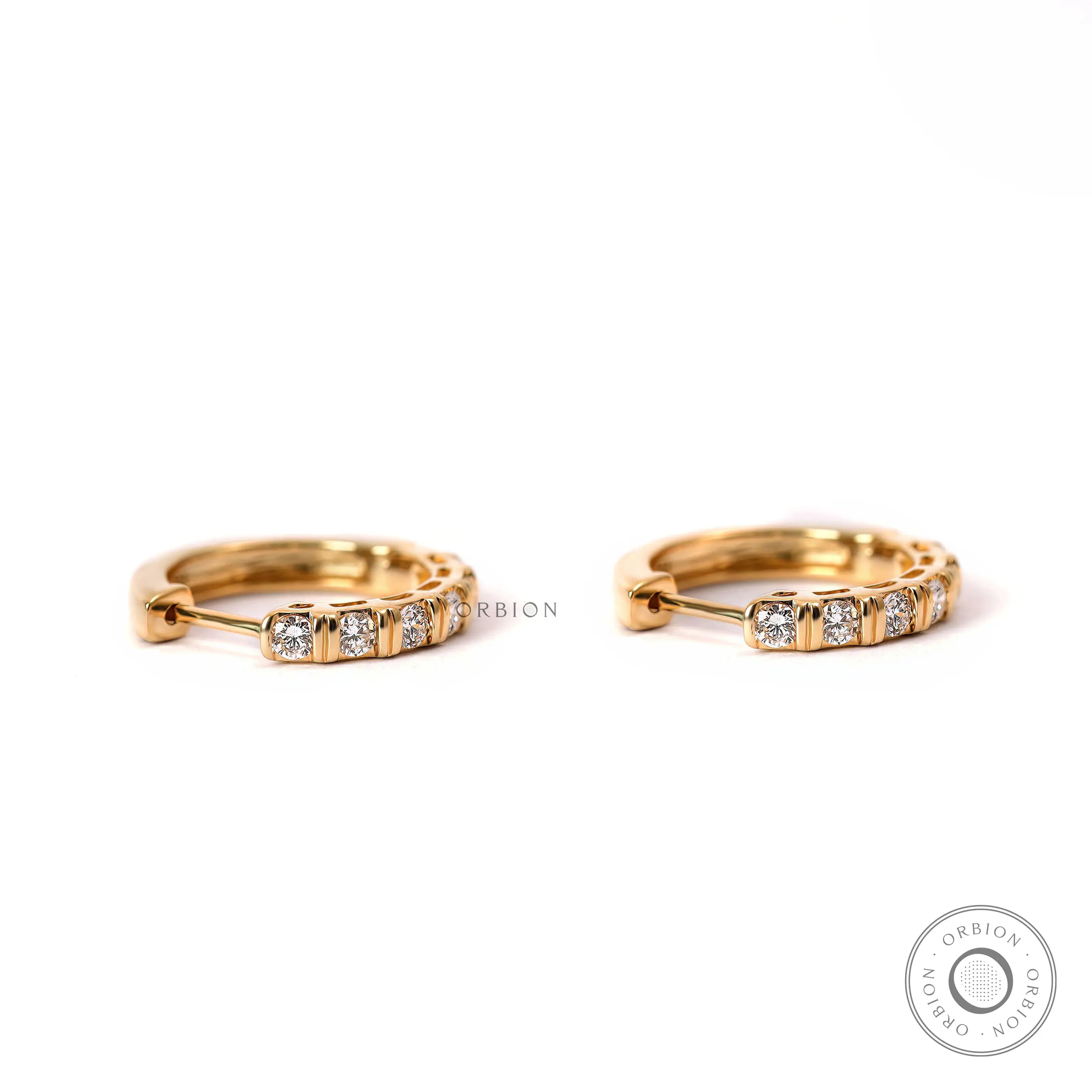 Yellow gold huggie hoop earrings with 2mm round lab diamonds close up