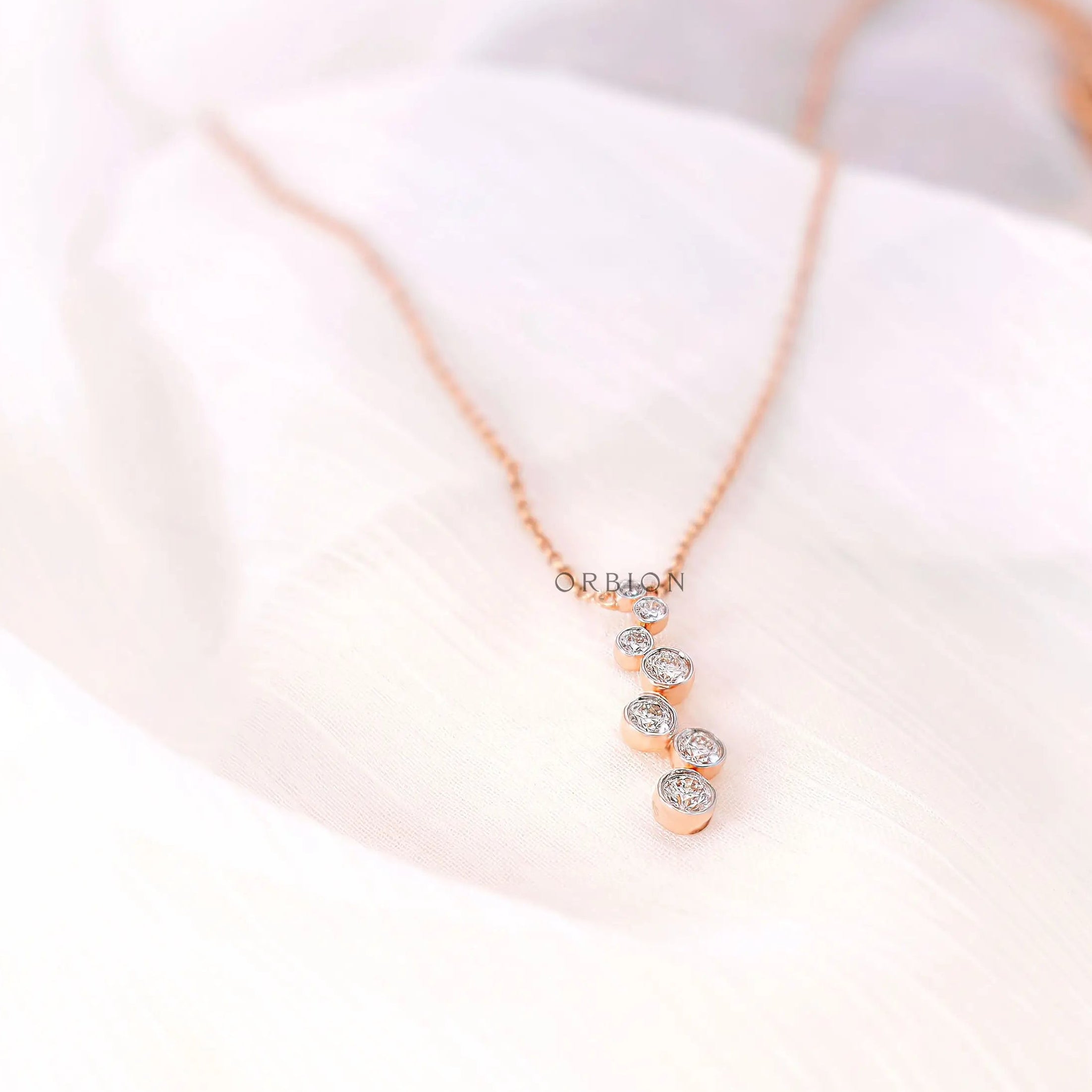Modern minimal diamond drop pendant necklace with graduated stones