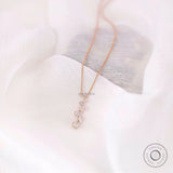 Close-up of bezel set round lab diamonds in vertical drop pendant design