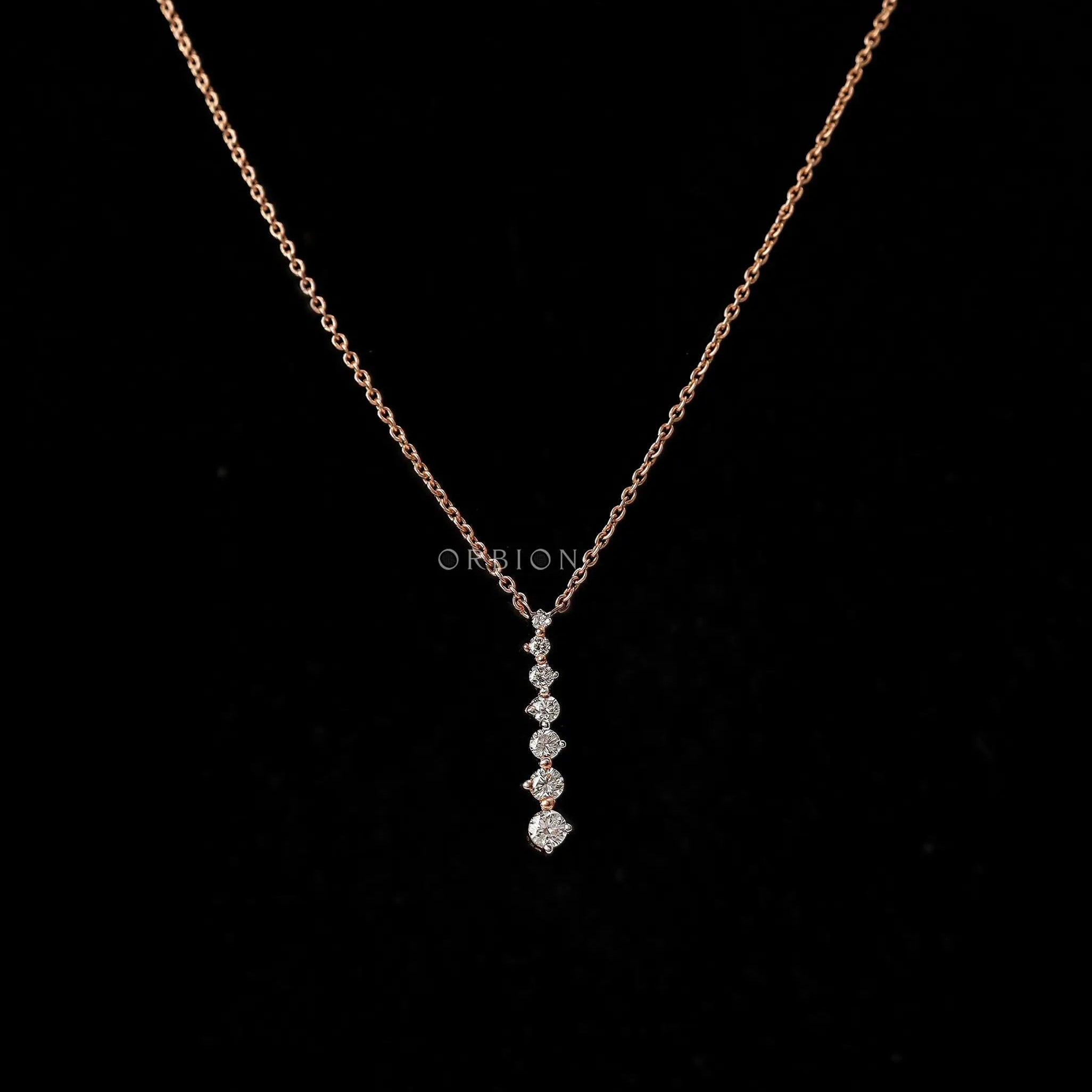 Dainty vertical graduating diamond pendant necklace in 14k rose gold, with a long drop design.
