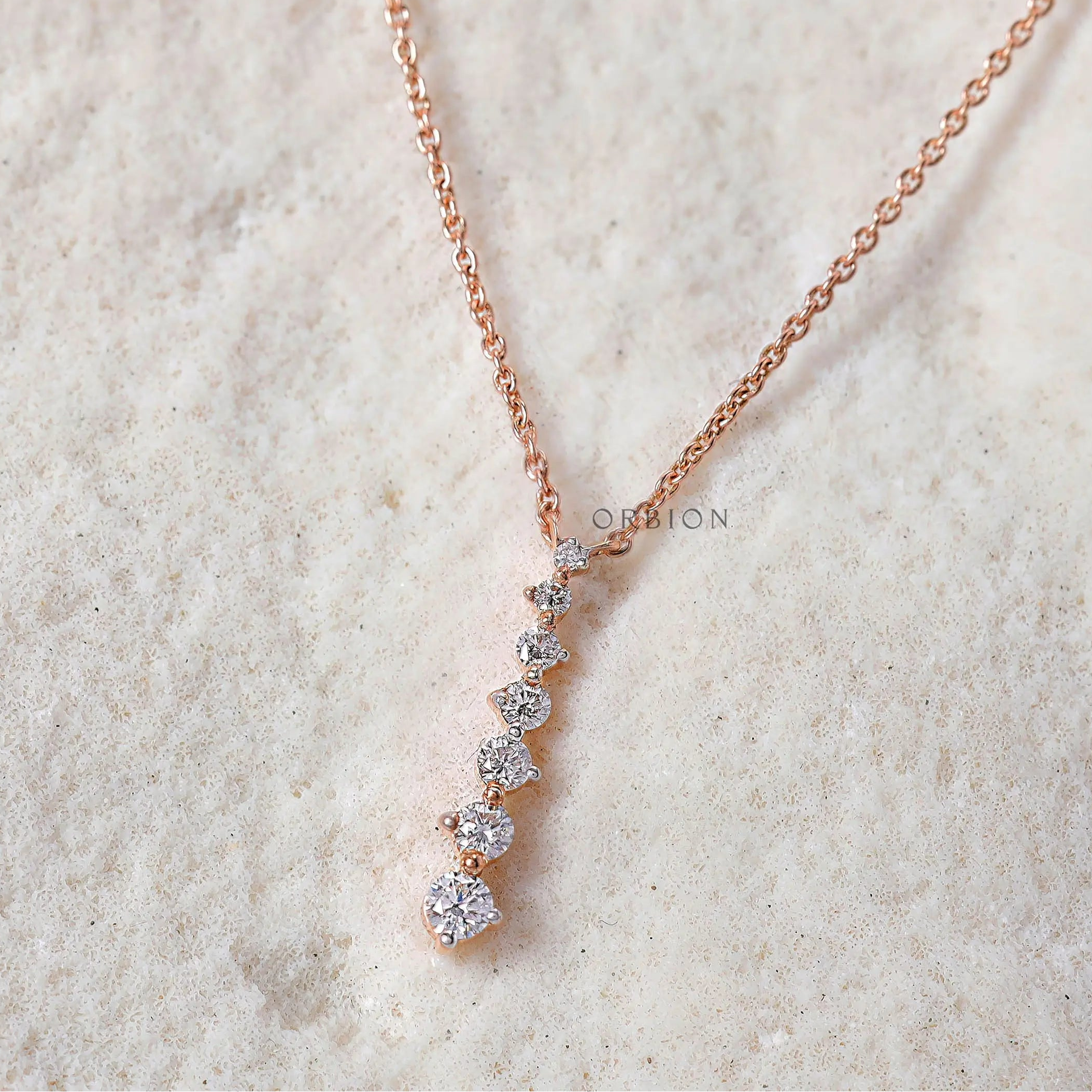 Lab-grown diamond pendant in a vertical line, with alternating diamond sizes and a smooth rose gold finish