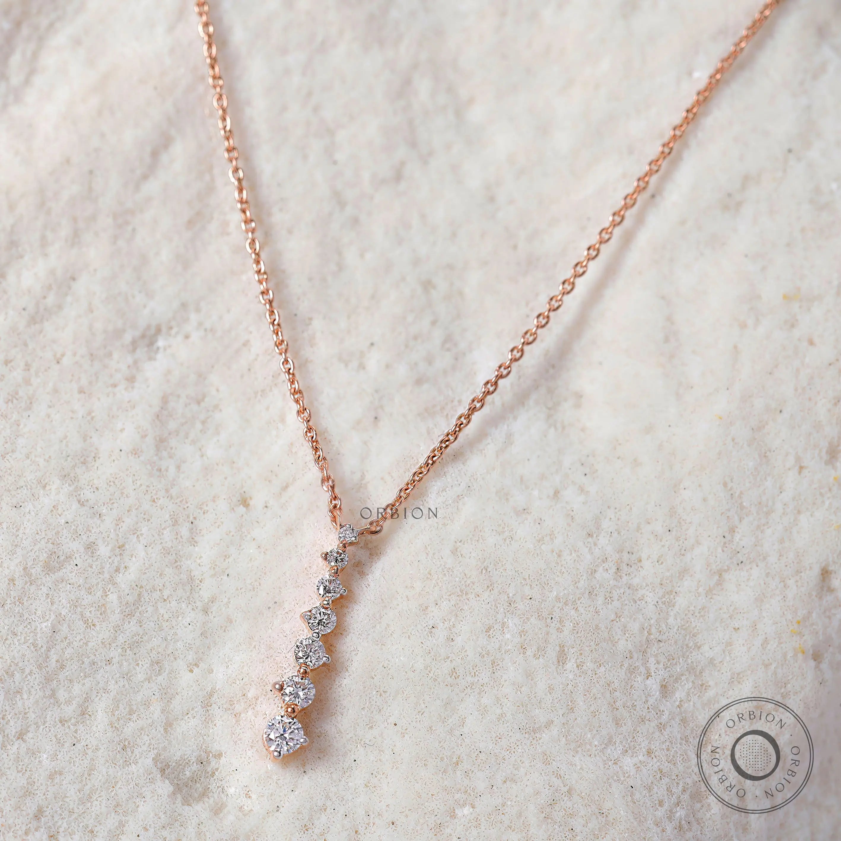 Lab-grown diamond pendant in a vertical line, with alternating diamond sizes and a smooth rose gold finish