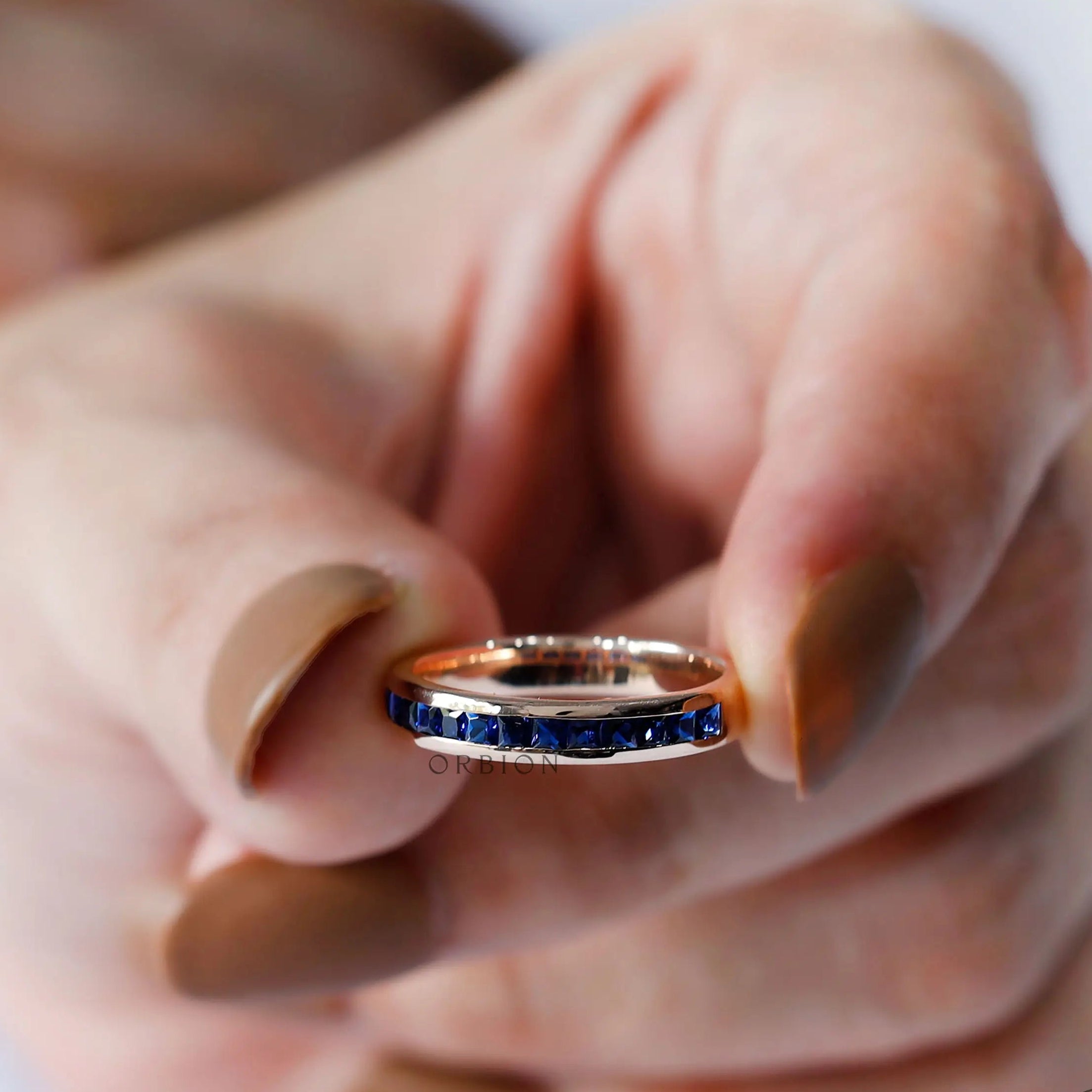 Blue sapphire half eternity ring on hand