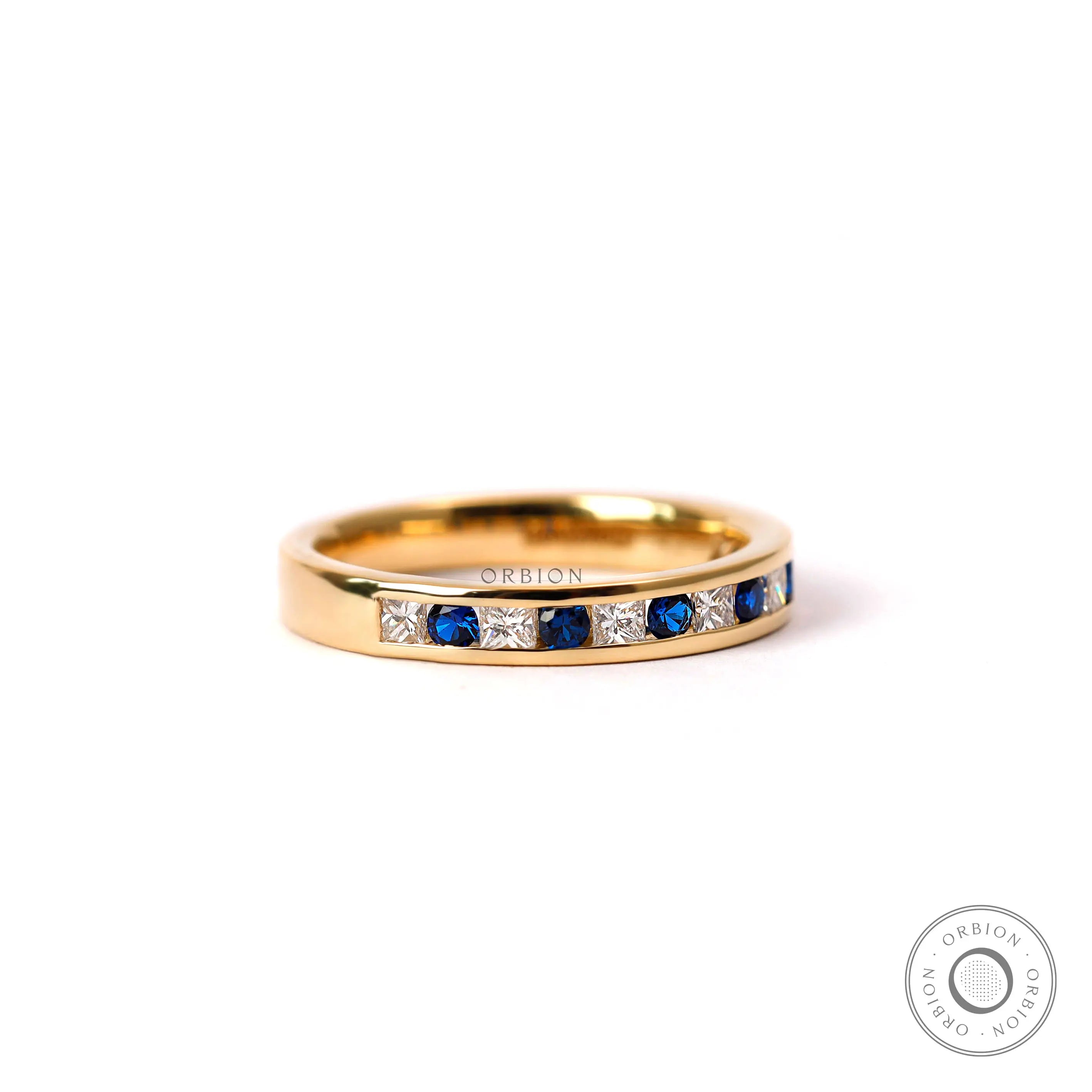 Alternating princess diamond and round sapphire channel set wedding band