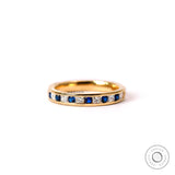 Channel set alternating diamond and blue sapphire half eternity wedding band yellow gold front view