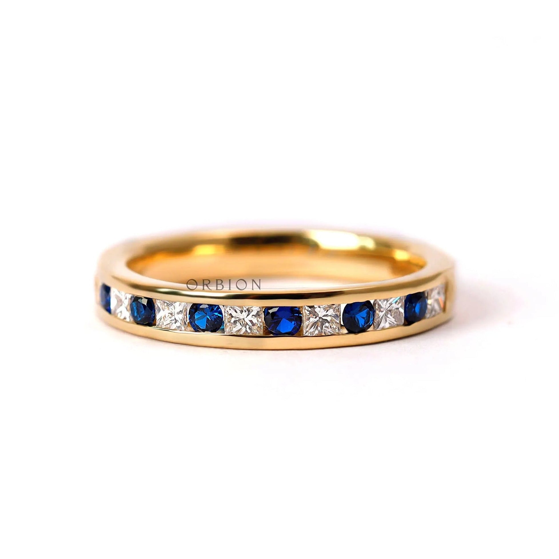 Channel set alternating diamond and blue sapphire half eternity wedding band yellow gold front view