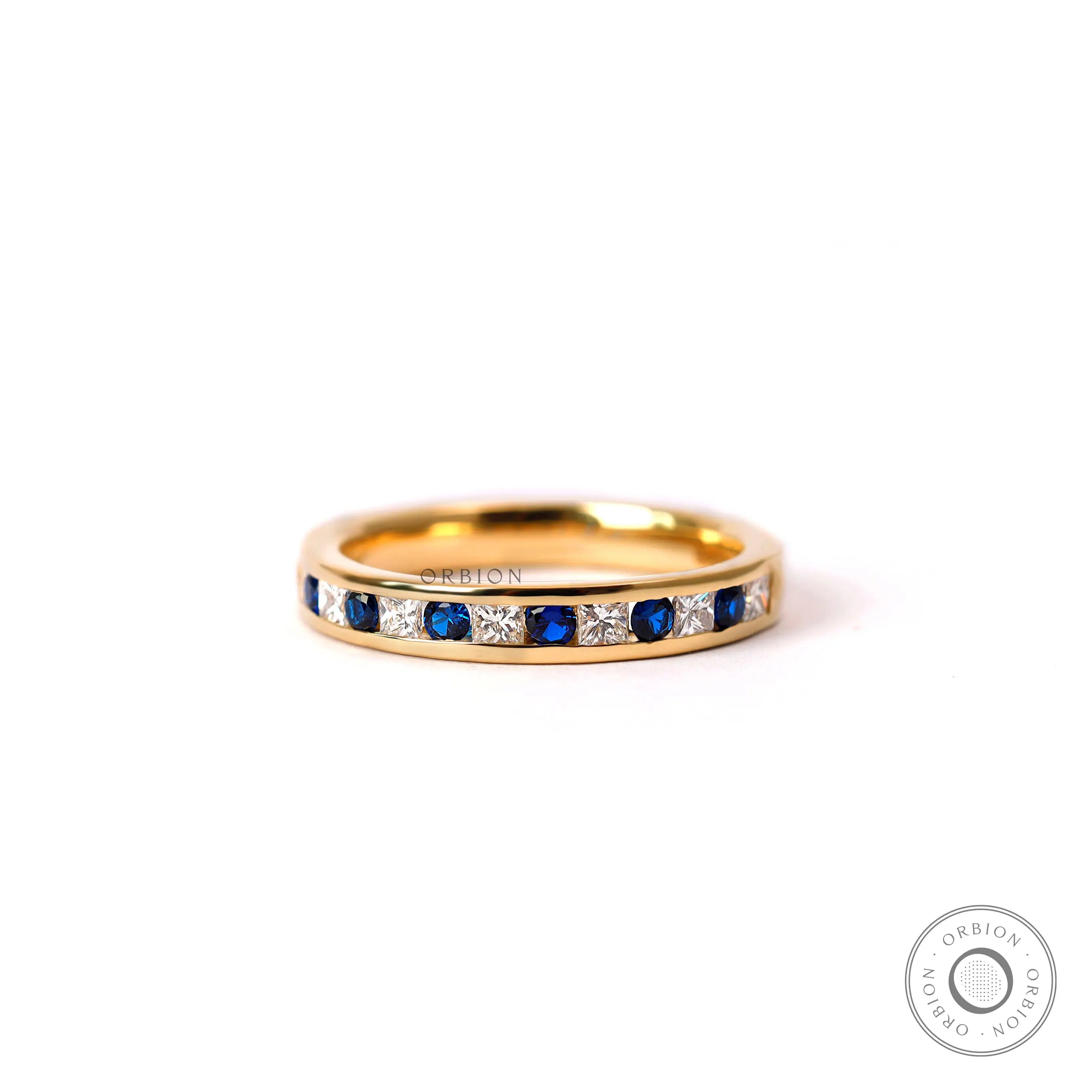 Channel set alternating diamond and blue sapphire half eternity wedding band yellow gold front view