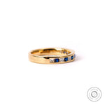 Diamond and blue sapphire half eternity band in yellow gold studio image