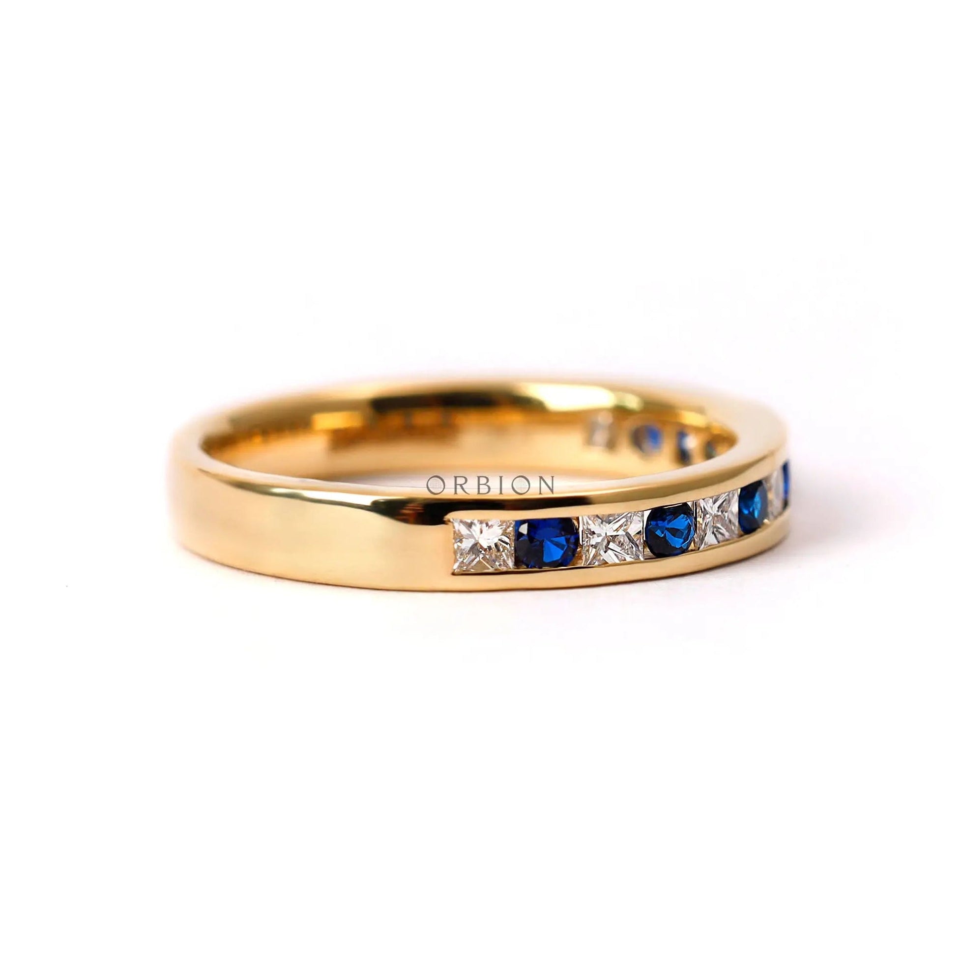 Diamond and blue sapphire half eternity band in yellow gold studio image