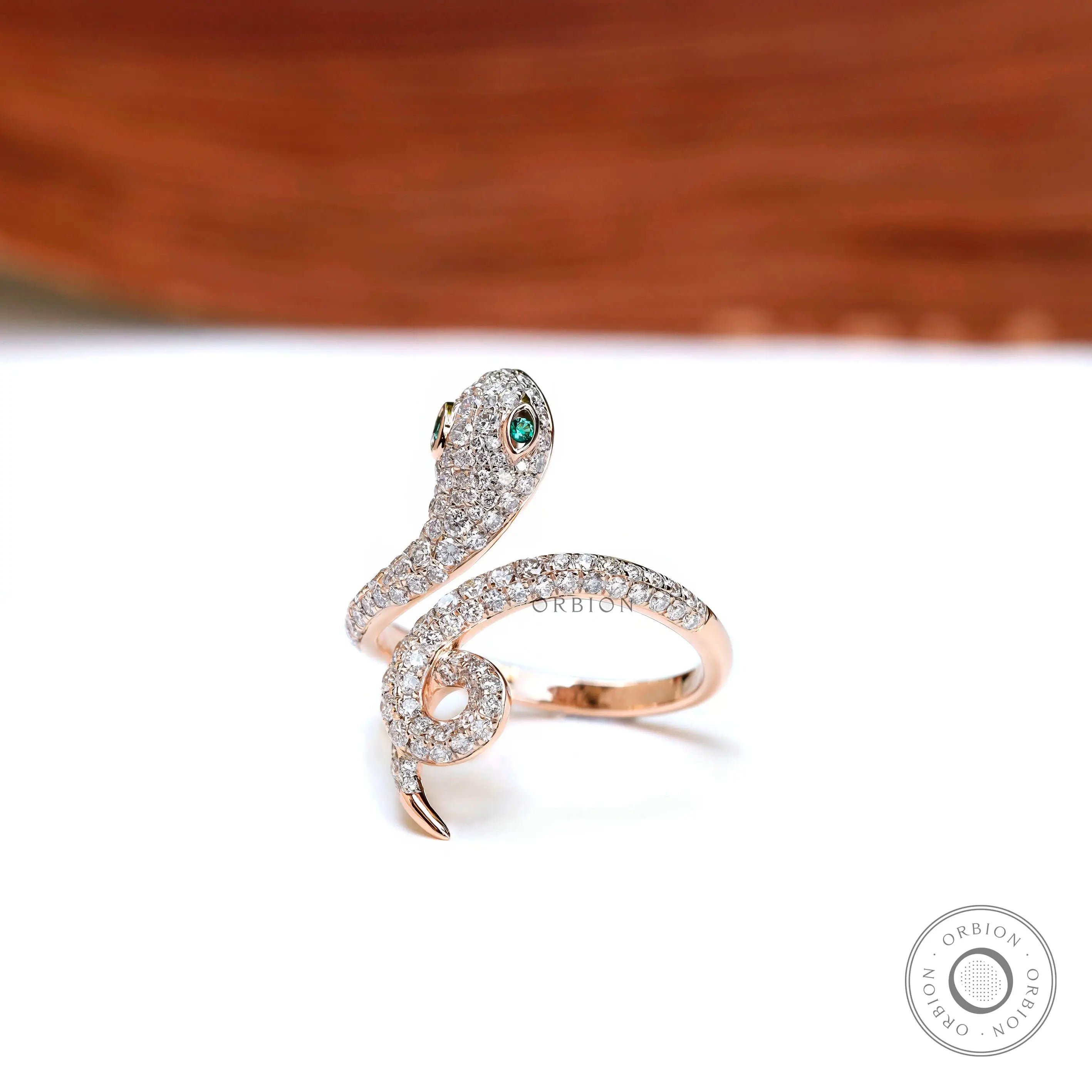 Side profile of rose gold snake ring with emerald eye detail