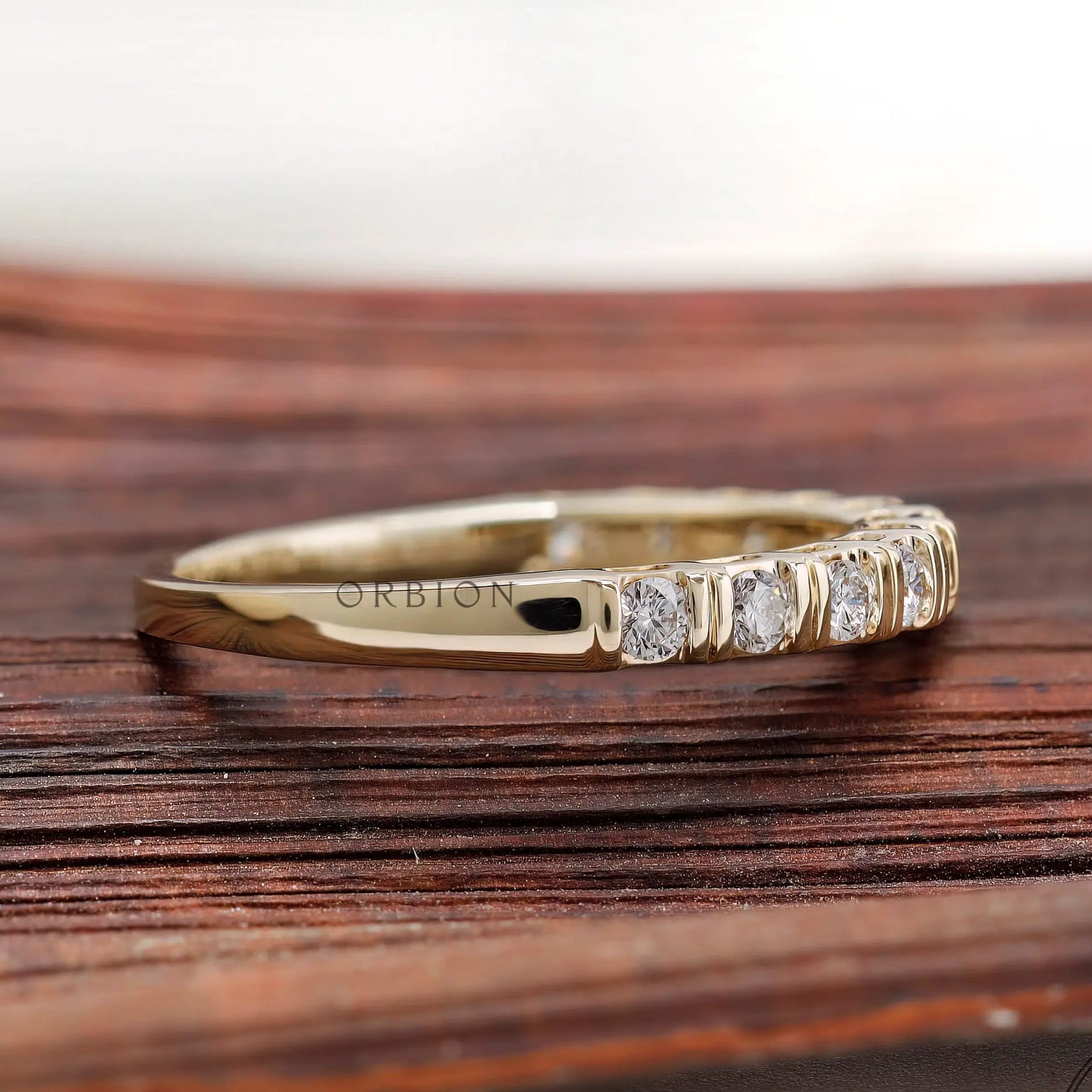 Side profile view yellow gold round diamond half eternity band