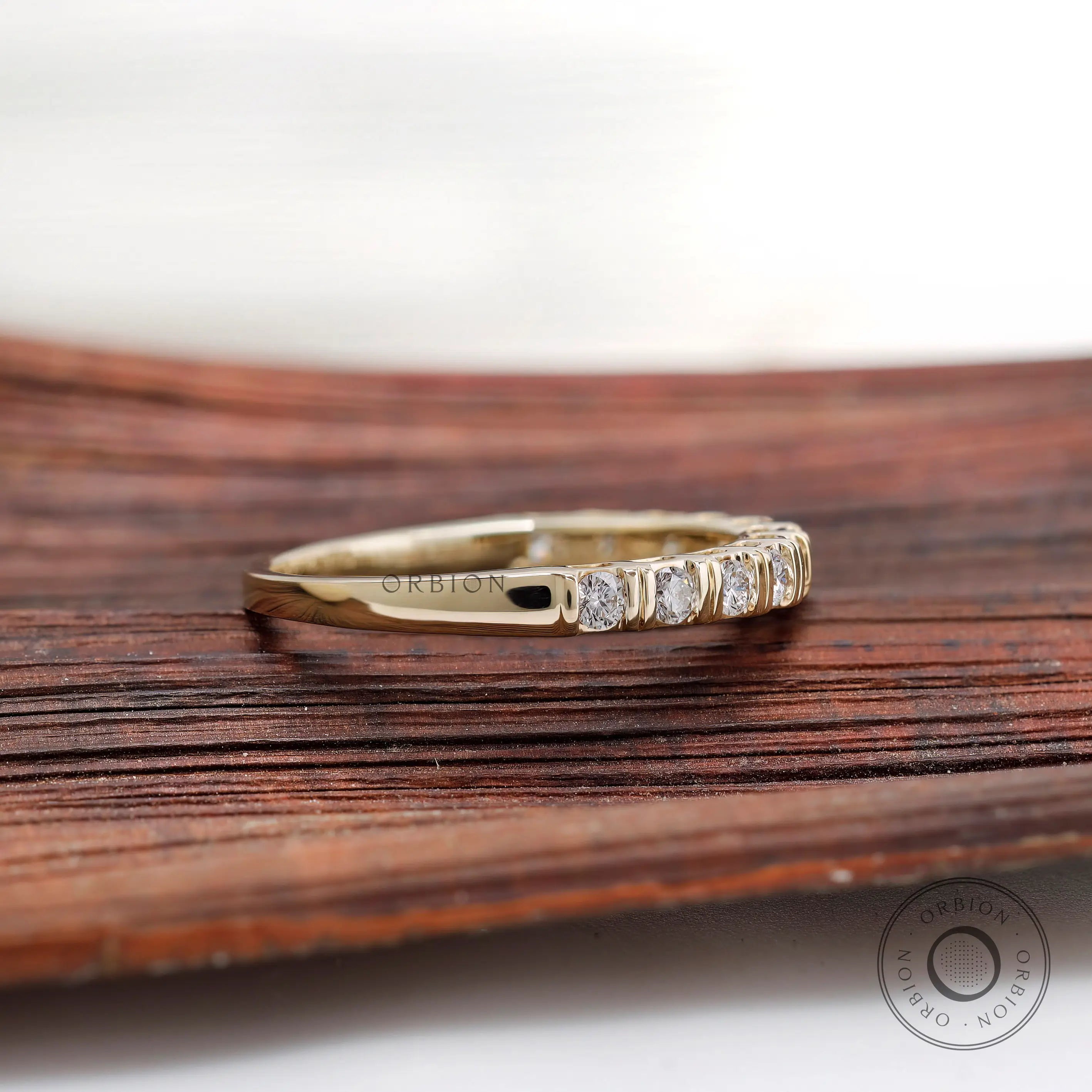 Side profile view yellow gold round diamond half eternity band