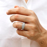 Iced out diamond dome wedding band style ring on finger